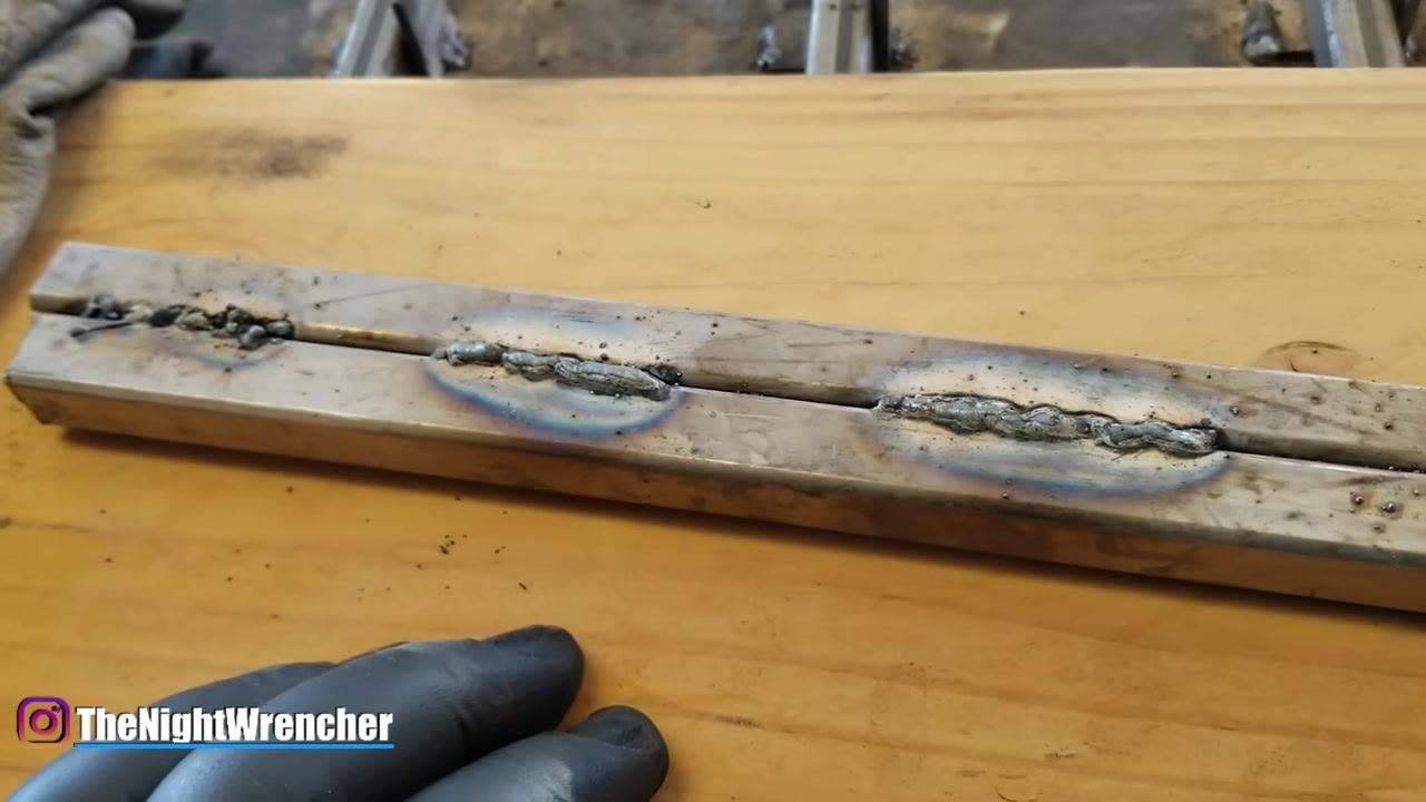 A gloved hand points at a cleaned weld bead on two metal bars, emphasizing the benefit of using anti-spatter spray to prevent spatter adhesion.