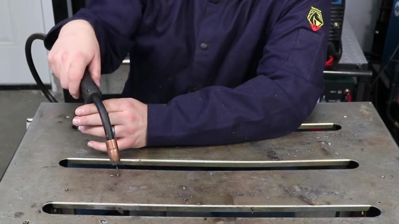 Welder performing a dry run, moving the MIG gun along the joint without activating the trigger to practice maintaining consistent stick out