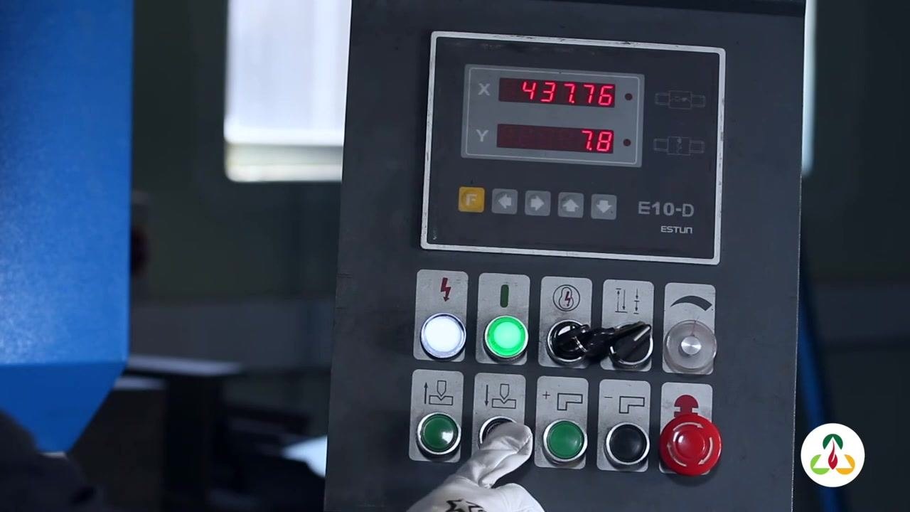 Close-up of the control panel display showing X = 437.76 and Y = 7.8. Gloved hand is pressing the downward arrow button to adjust the pressure for square shape forming.