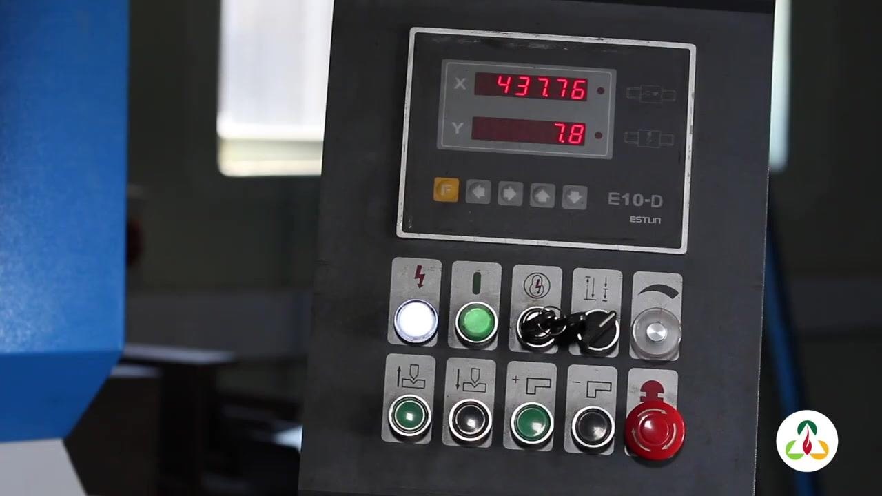 Close-up of the E10-D ESTUN control panel with digital displays showing X = 437.76 and Y = 7.8, indicating the final settings used for the square bend. Various control buttons and indicator lights are visible.