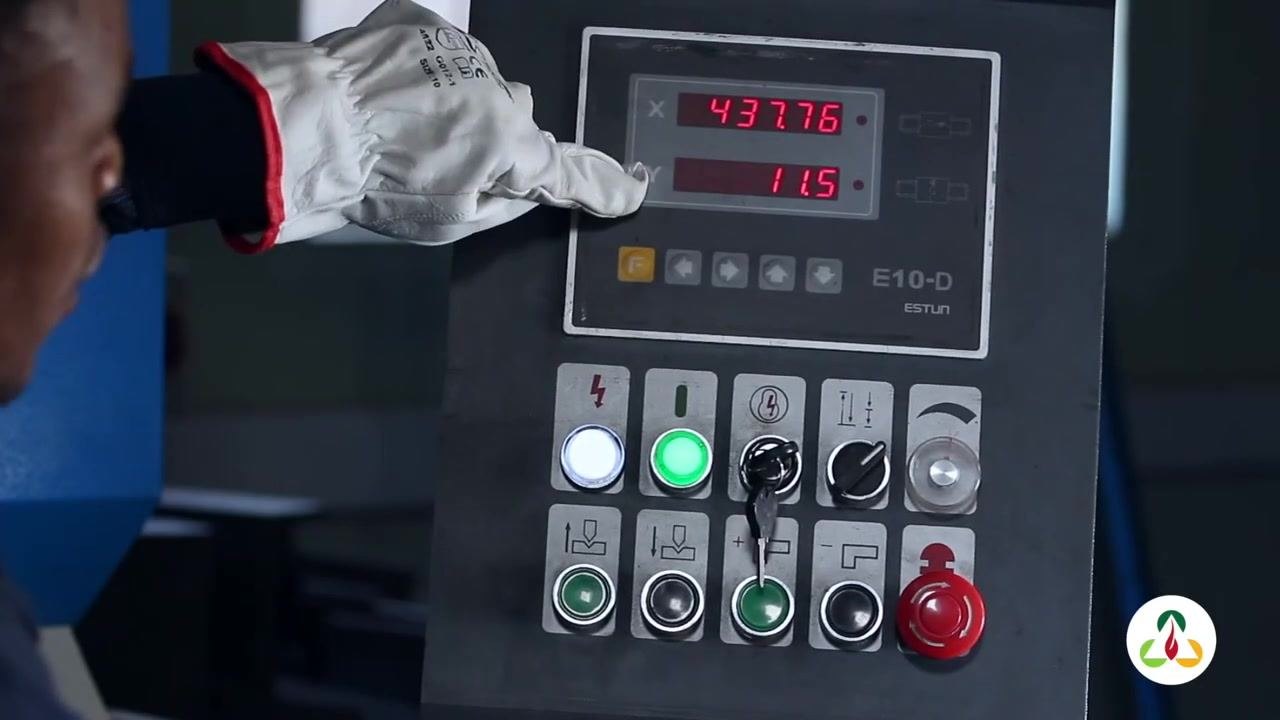 Operator's gloved hand pointing to the control panel, indicating the adjustment of the Y value