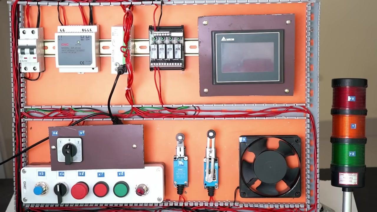 Electrical panel with PLC, HMI, push buttons, selector switches, limit switches, fan, and stack light. All components are labeled and wired.