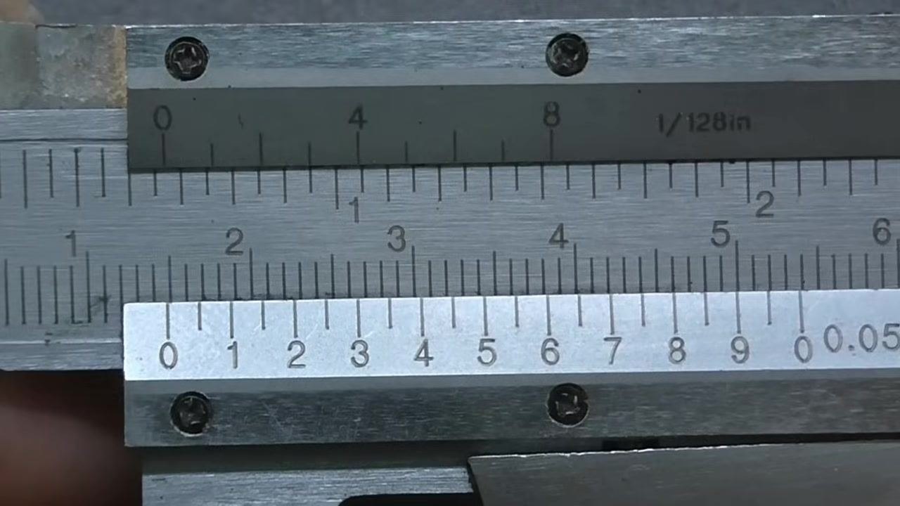 Close-up of a vernier caliper with the vernier scale zero aligned exactly with the main scale zero. All scale markings are clearly visible.