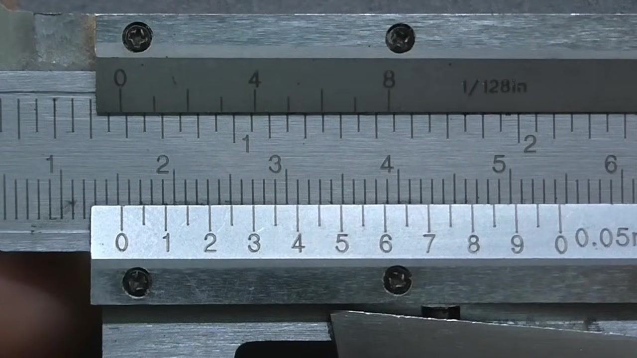 Vernier caliper with the vernier scale zero just past the 15 mm mark on the main scale.