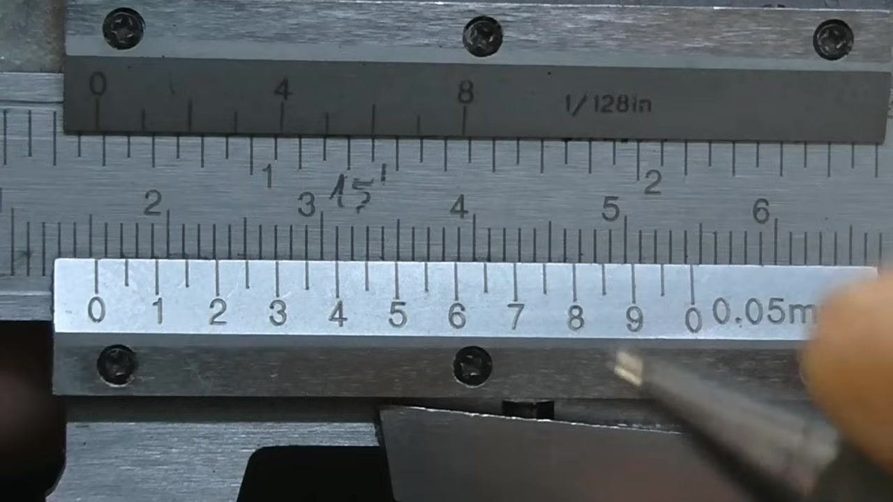 Vernier caliper with a pen pointing along the vernier scale while searching for lines that coincide with the main scale.