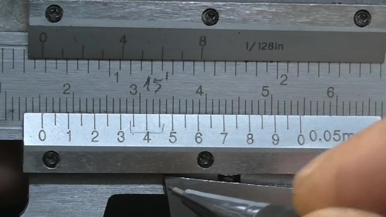 Vernier caliper with a pen pointing at the coinciding lines on the vernier and main scales, marking the precise measurement point.