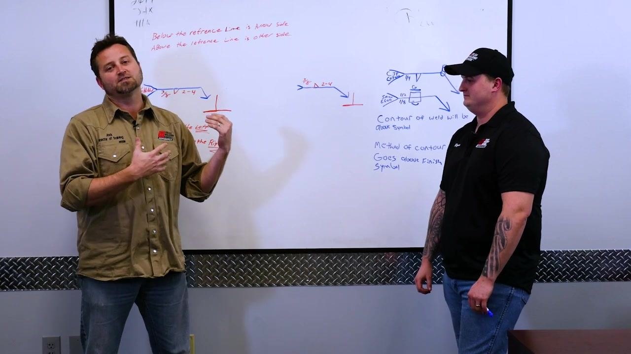 Two instructors stand in front of a whiteboard with welding symbols, arrows, and handwritten notes in red and blue marker. The left instructor is speaking, the right is holding a marker. Visible notes include "Below the reference line is arrow side," "Above the reference line is other side," "SIZE is to the left," and "Length or Pitch to the Right." Several welding symbols and arrows are drawn.