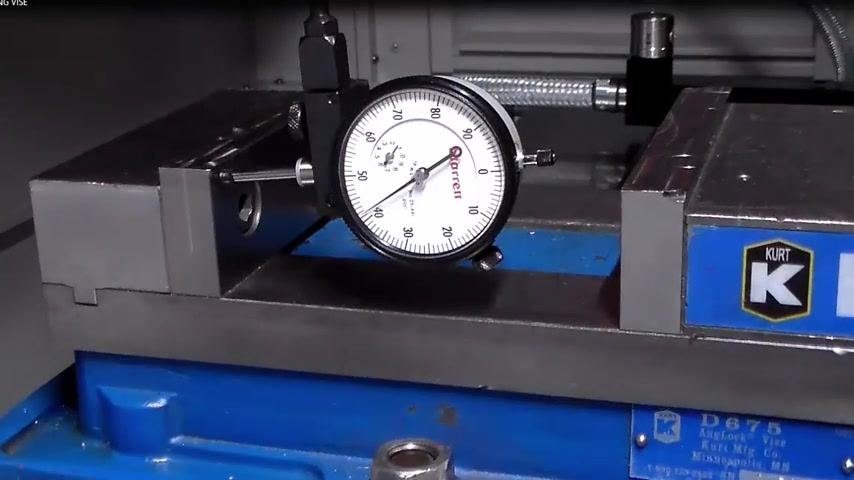Dial indicator showing final alignment, vise bolts tightened, setup complete