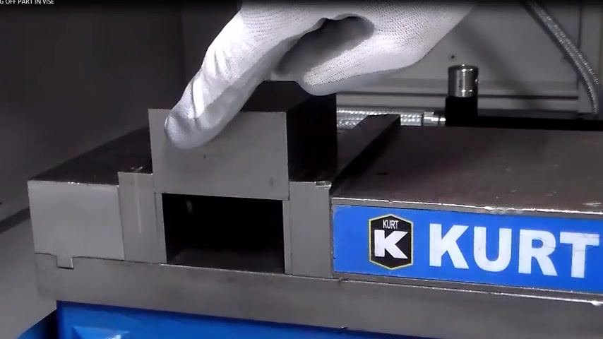 Gloved hand pointing to the left and front sides of the part in the vise, indicating where to set X and Y with the edge finder