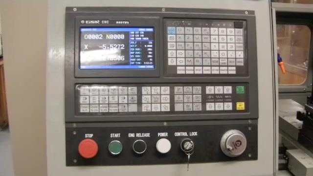 Close-up of the CNC lathe control panel with the controller screen powering up, displaying the GSK CNC startup interface.