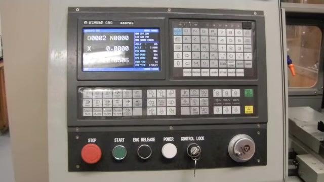 CNC lathe control panel with the controller display showing X = 0.0000, confirming the machine is at the home position.