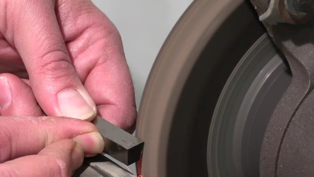 Grinding resumes on the tool bit, maintaining the correct angle and gap.
