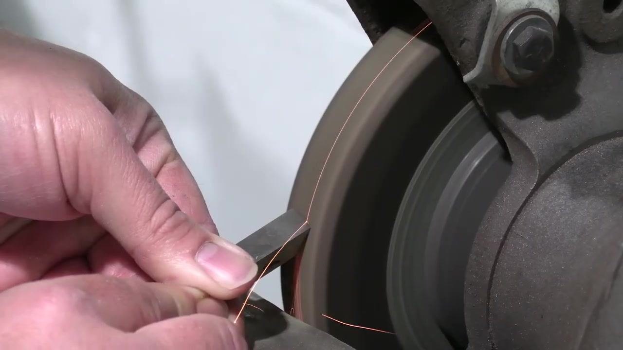 The tool bit is held in front of the grinding wheel, preparing to address the straight edge.