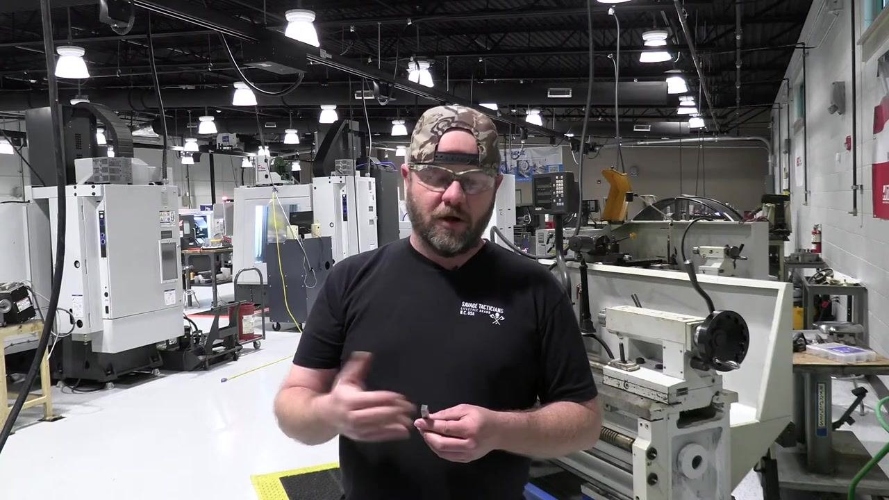 The tool bit is positioned at the bench grinder, ready to begin the first grinding pass.