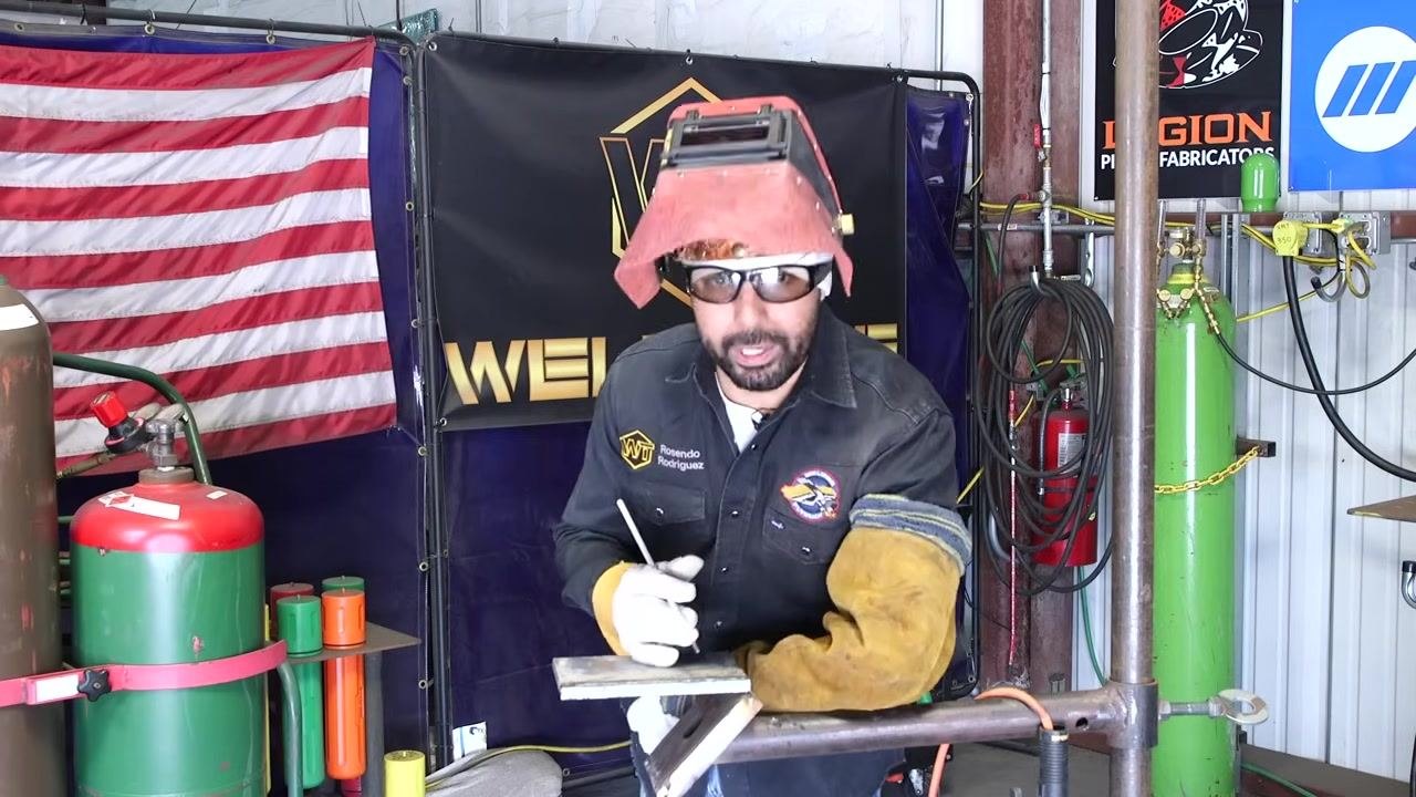 A welder at the station explains bead guidance and uniformity, with welding equipment visible in the background.