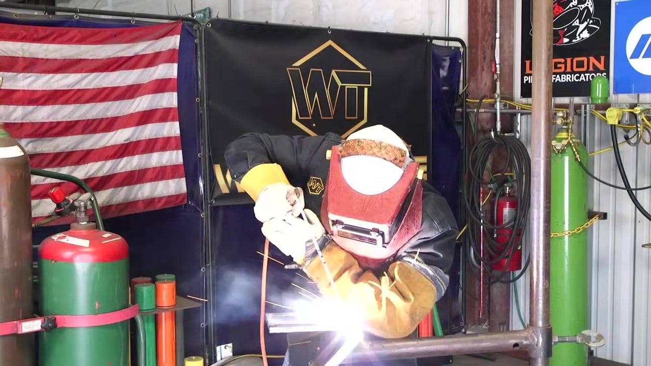 Welding continues with an adjusted rod angle and focus maintained on the puddle, sparks visible.