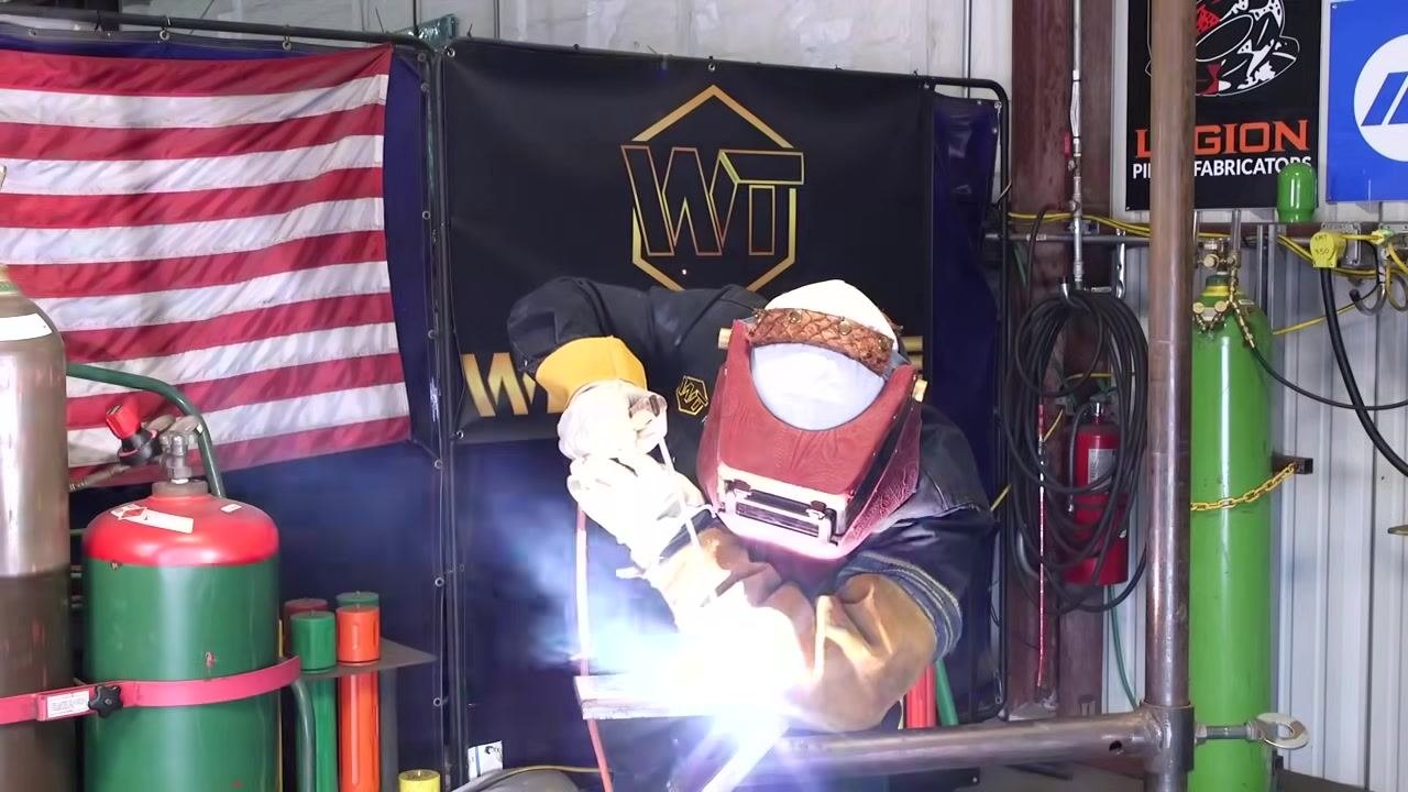 Instructor continuing to weld, with arc and sparks. Emphasis on technique and safety.