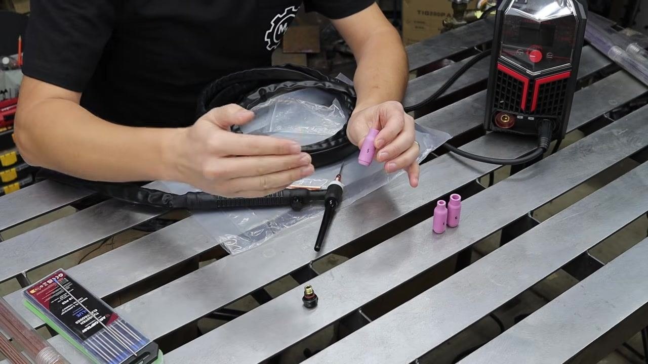 Hand pointing to the number 5 marking on an alumina nozzle cup to confirm the opening size.