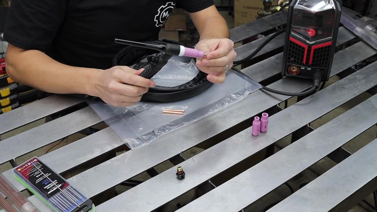 Hand tightening the back cap on the assembled TIG torch to confirm the setup is complete.