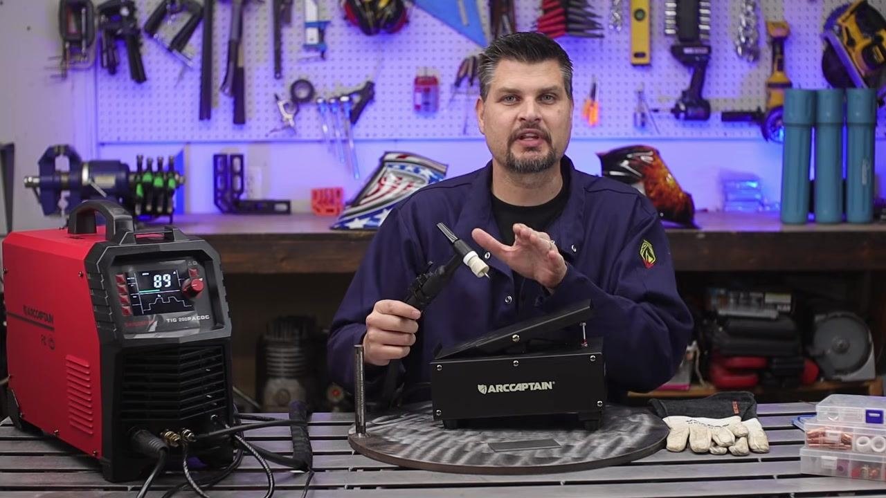Person summarizing arc control while holding the torch and foot pedal, with the welder and accessories visible.