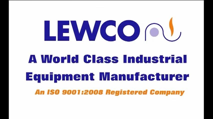 A person wearing safety glasses and a microphone headset stands in an industrial workshop. The lower third of the screen displays the name "John Kennedy" and the title "LEWCO Assembly Cell Leader." Background includes industrial equipment and overhead cranes.