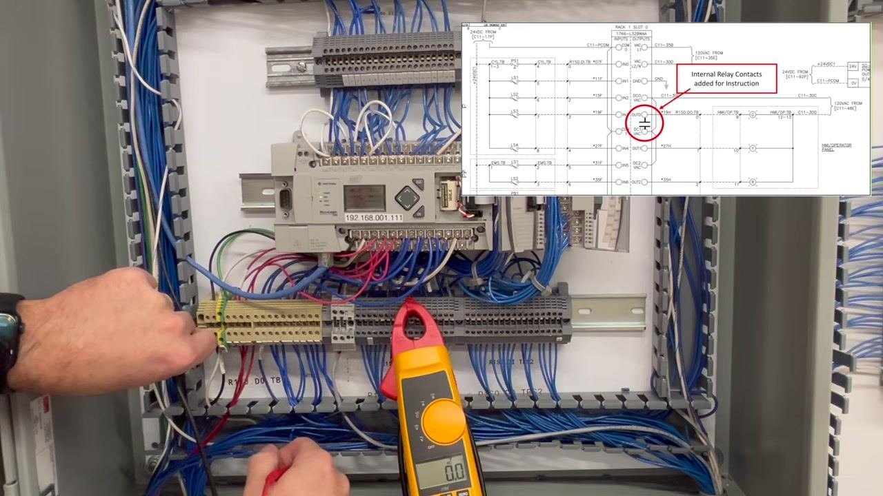 The red probe is removed while the black probe remains, with the meter reading 0.0V and the schematic overlay visible.