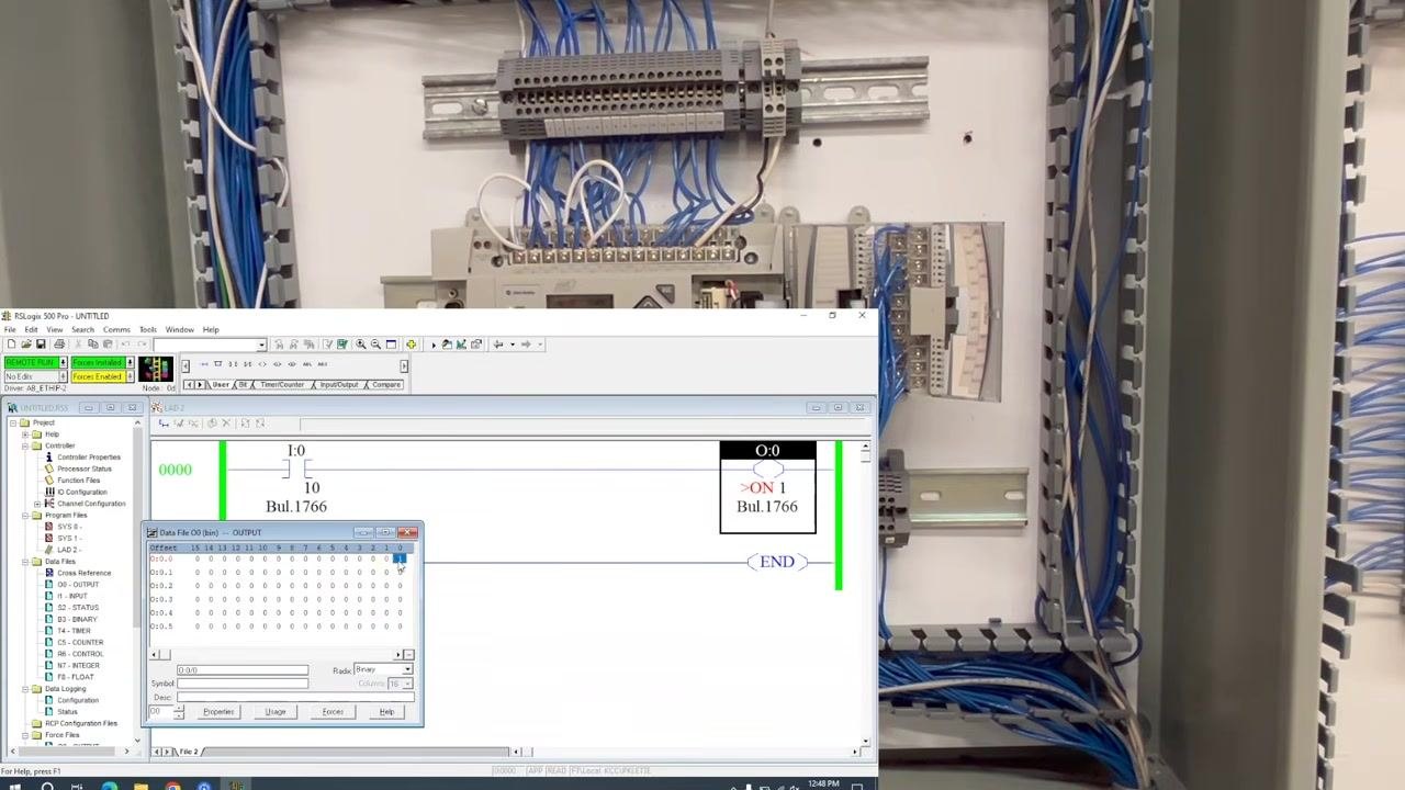 RSLogix 500 Pro software interface with the ladder logic, output forced ON, and status bar showing "Force Enabled" and "Process Inhibited".