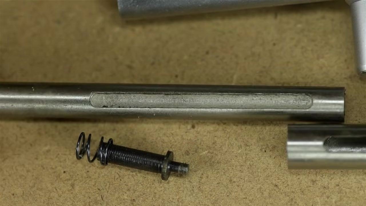 Macro view of the plunger slot, showing ragged edges and burrs from poor factory deburring.