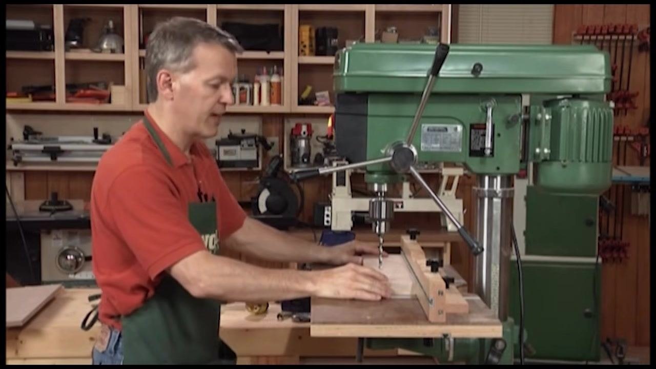 Operator holding a workpiece against the fence to demonstrate improved drilling safety