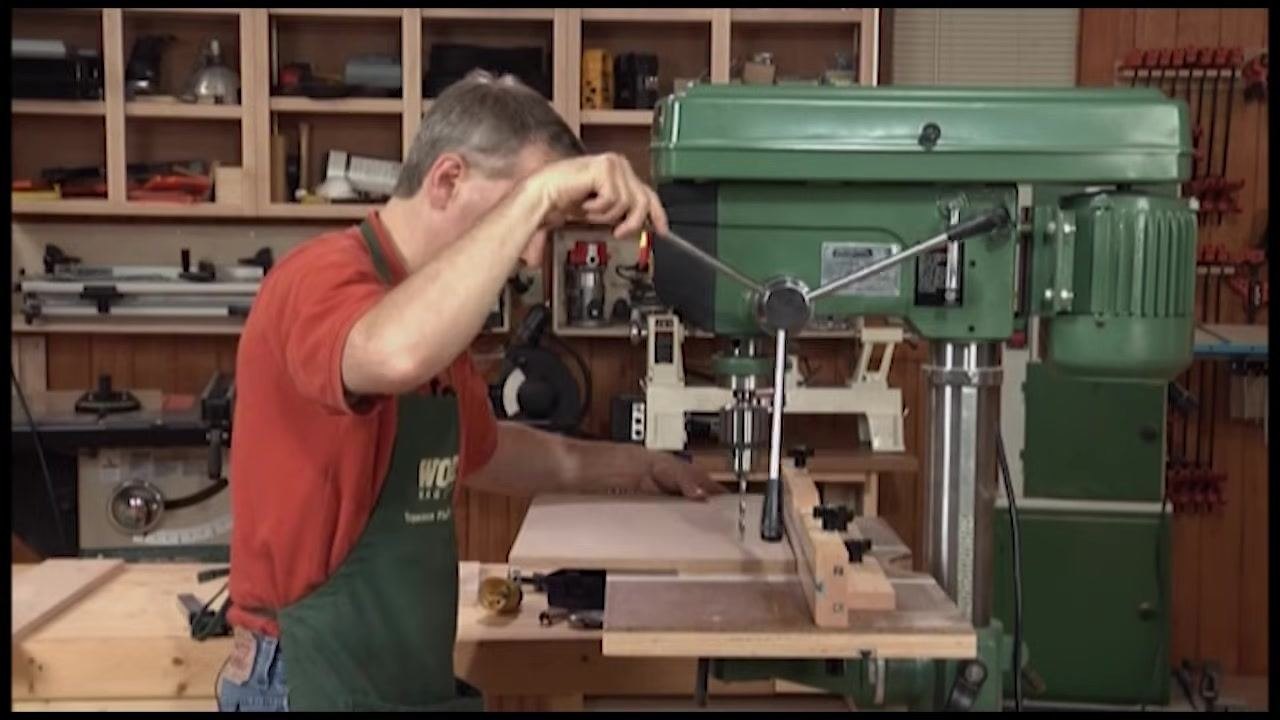 Operator resolving a handle clearance issue by unscrewing the handle to allow full travel of the drill press