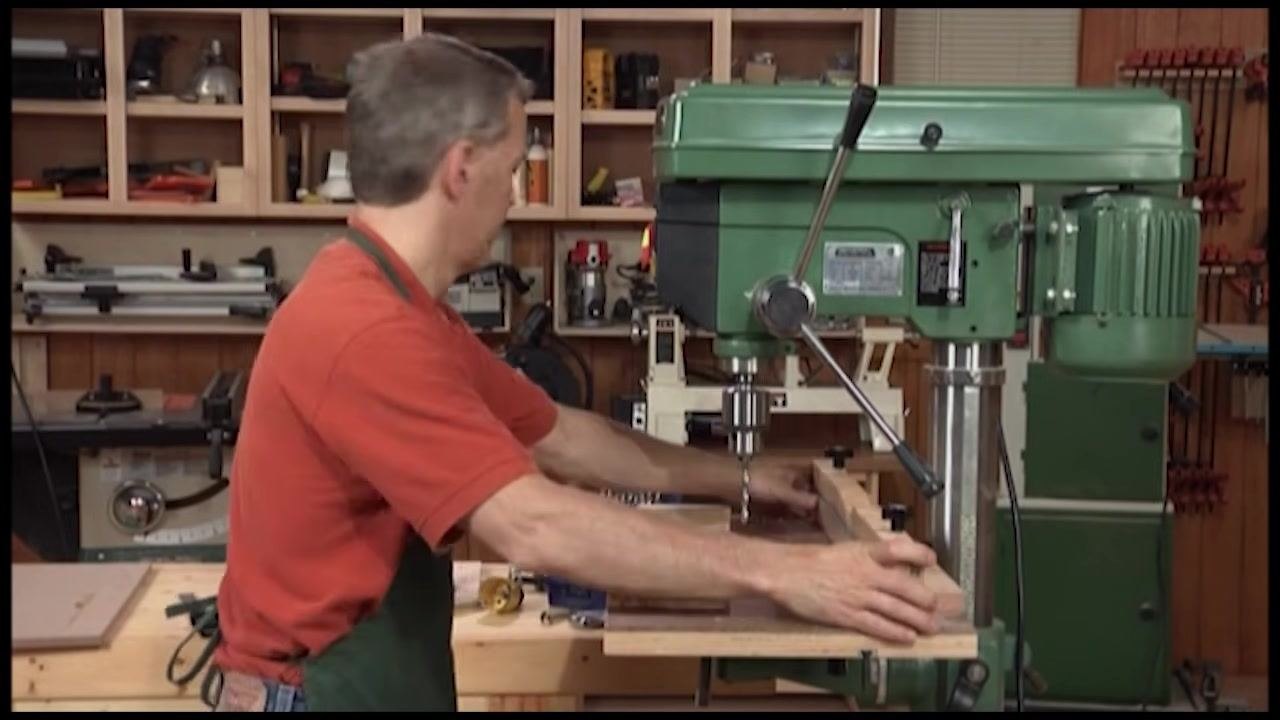 Drum sander attachment installed in the drill press chuck, with the fence visible on the table