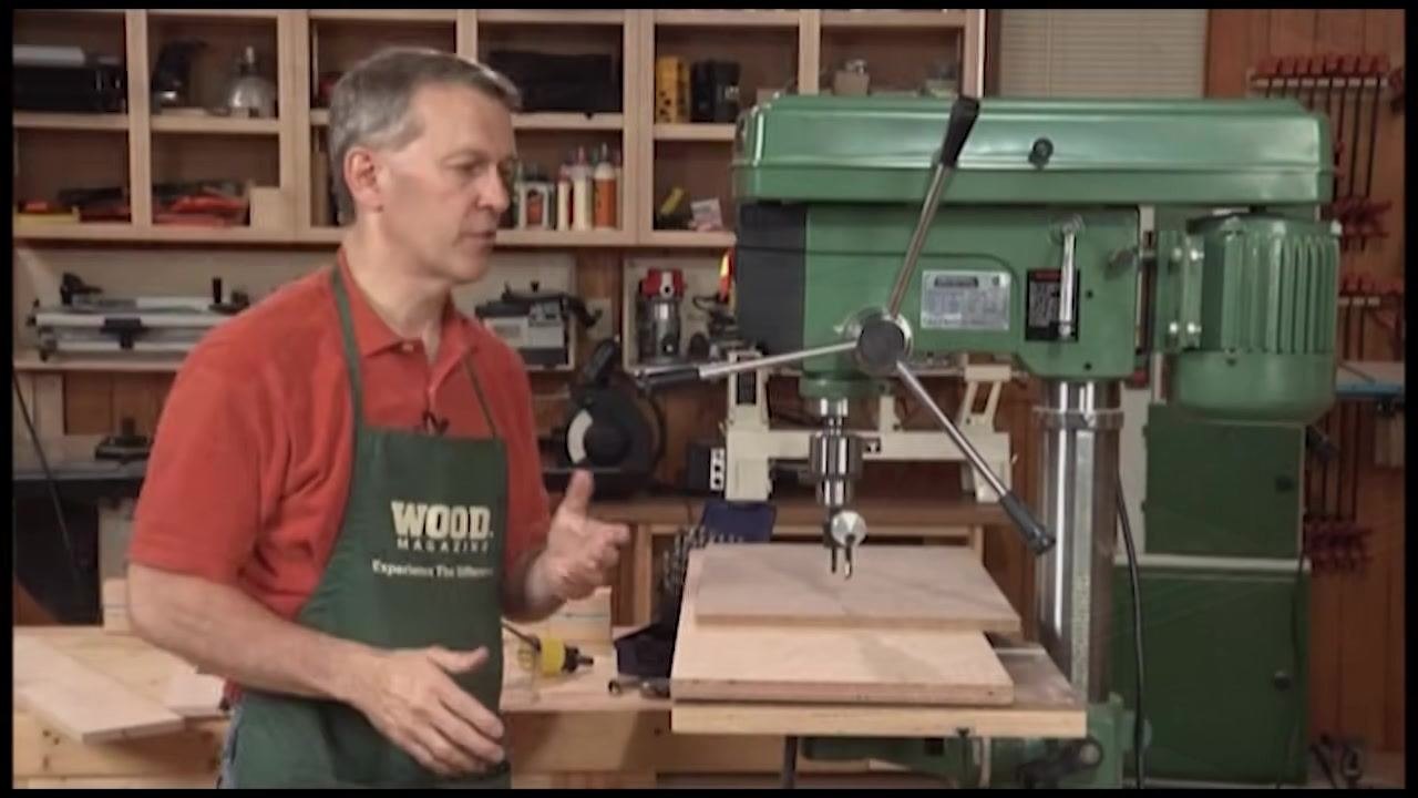 Operator adjusting the drill press table height with the workpiece positioned under the drum sander