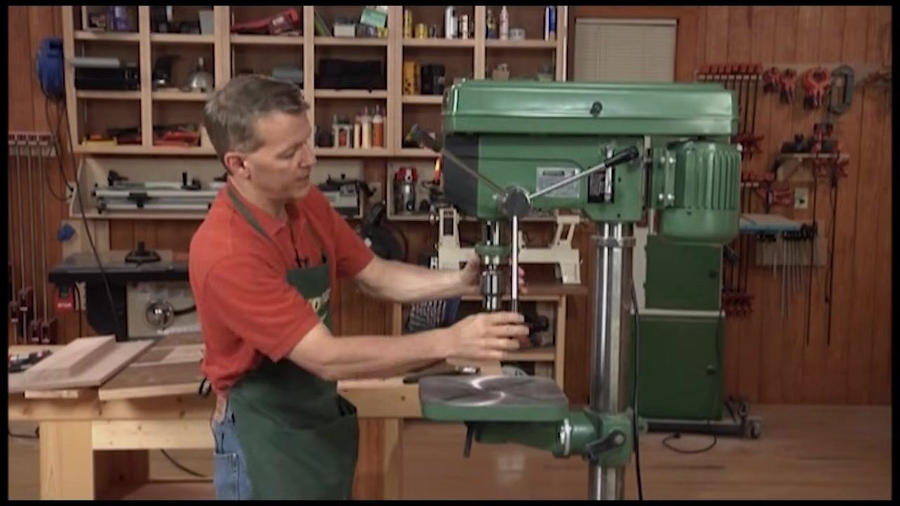 Operator raising and lowering the quill assembly using the side handle of the drill press