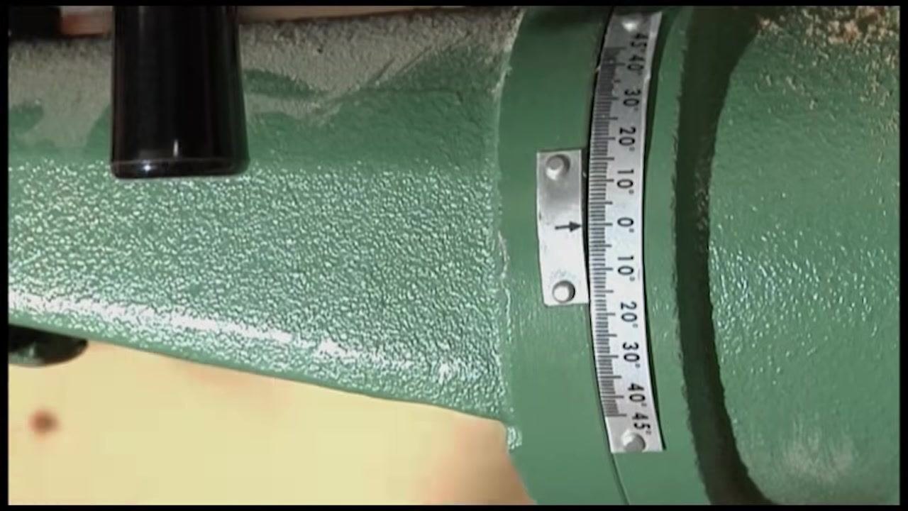 Close-up of the drill press table tilt gauge showing degree markings and an indicator arrow
