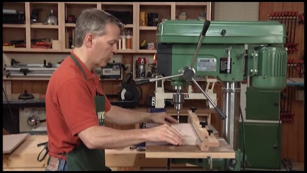 Operator positioning a workpiece against the adjustable fence for consistent hole spacing