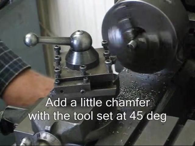 Lathe running with the tool set at 45 degrees against the spinning workpiece to add a chamfer.