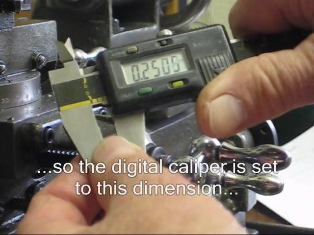 Mild steel rod mounted in the lathe chuck, with the operator's hand adjusting the setup.