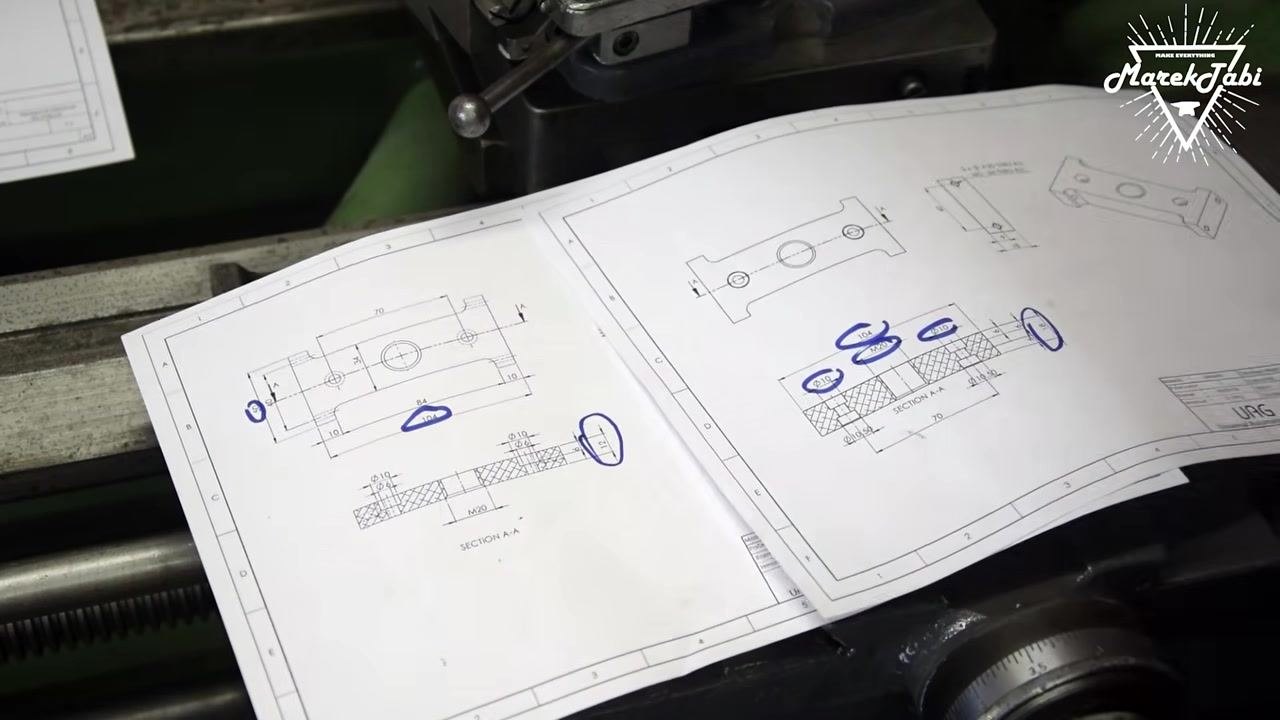 Technical drawings with all relevant features circled, laid out on the machine bed for reference.