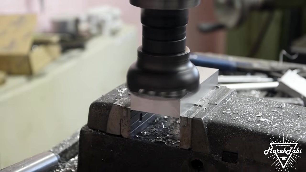 A face mill cutter performing additional milling passes on a different face of the billet, ensuring all surfaces are flat and parallel.