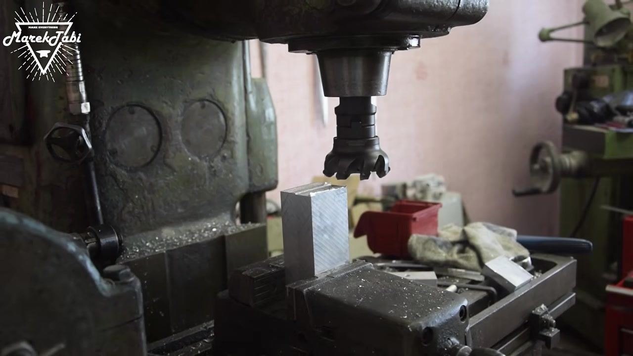 A face mill cutter aligned above the billet, ready for machining, with the billet clamped in a clean and organized setup.