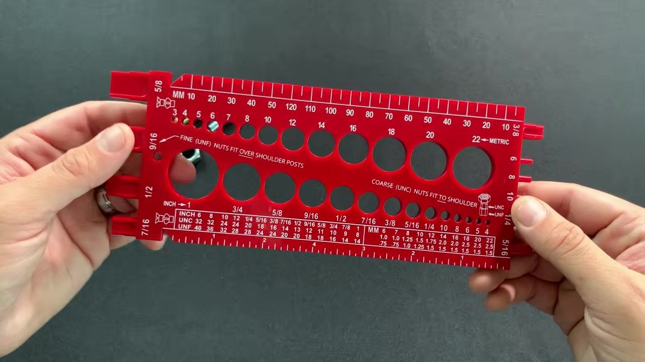 Back of the red thread gauge, highlighting indents for thread pitch measurement and side posts for nut measurement, with the labels "FINE (UNF) NUTS FIT OVER SHOULDER POSTS" and "COARSE (UNC) NUTS FIT TO SHOULDER" visible.