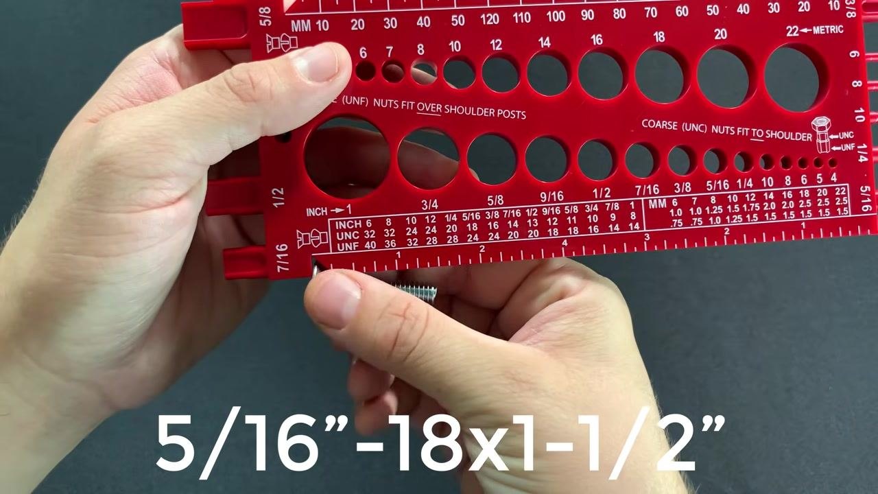 A nut being inserted into the gauge holes to determine its size, held with both hands, with a bolt visible on the side.