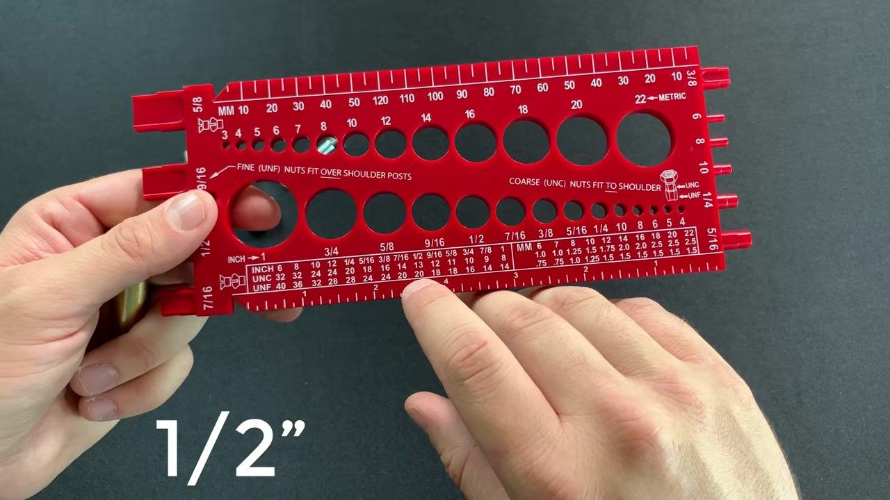 The back of the gauge with a finger pointing to the raised thread pitch grooves labeled "United States Thread Pitch" and "Metric Thread Pitch," with the 1/2 inch bolt ready for pitch measurement.