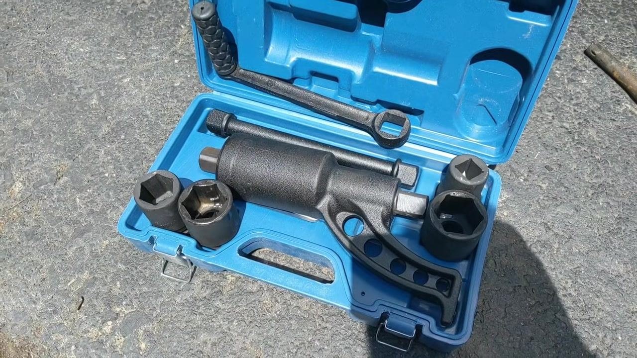 Open blue torque multiplier kit on the pavement, showing the torque multiplier, sockets, handle, and extension bar neatly arranged in molded slots