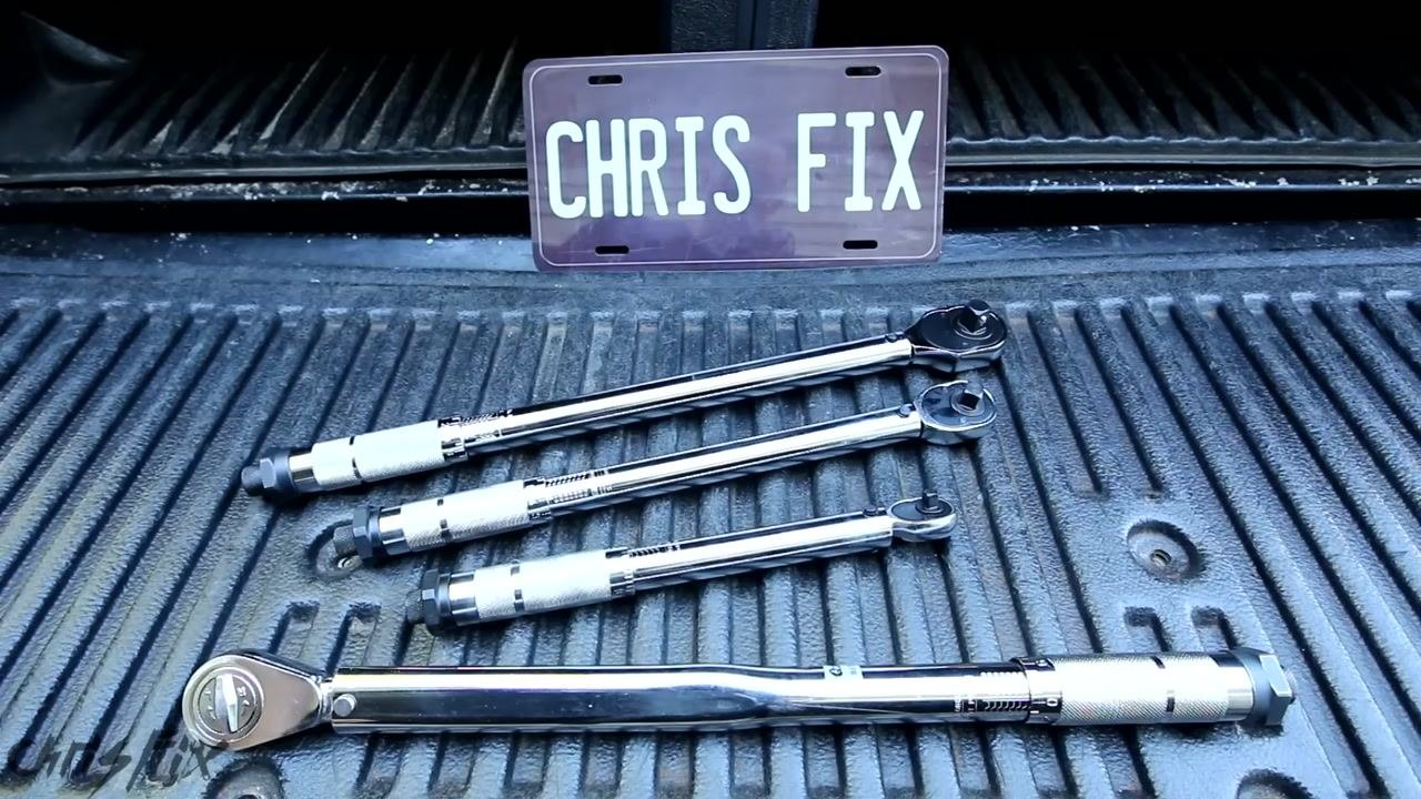 Four torque wrenches of different sizes laid out in a truck bed, with a "CHRIS FIX" plate in the background