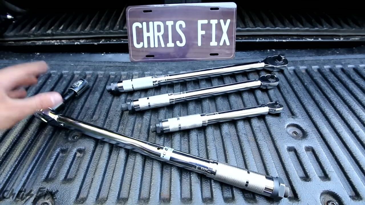 Four torque wrenches of different sizes laid out in a truck bed, with a "CHRIS FIX" plate in the background, summarizing the tools used