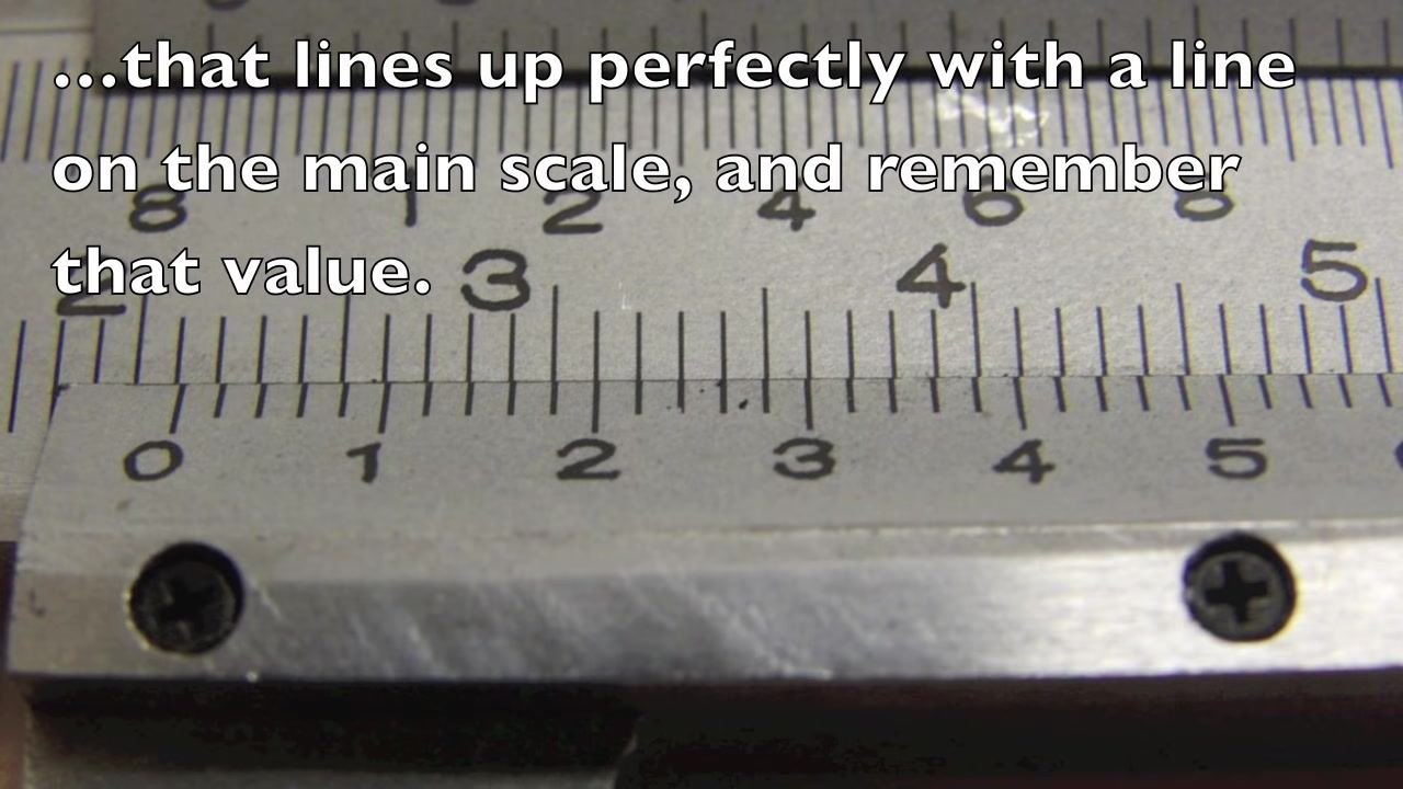 Close-up of the vernier and main scale with on-screen text: "...that lines up perfectly with a line on the main scale, and remember that value."
