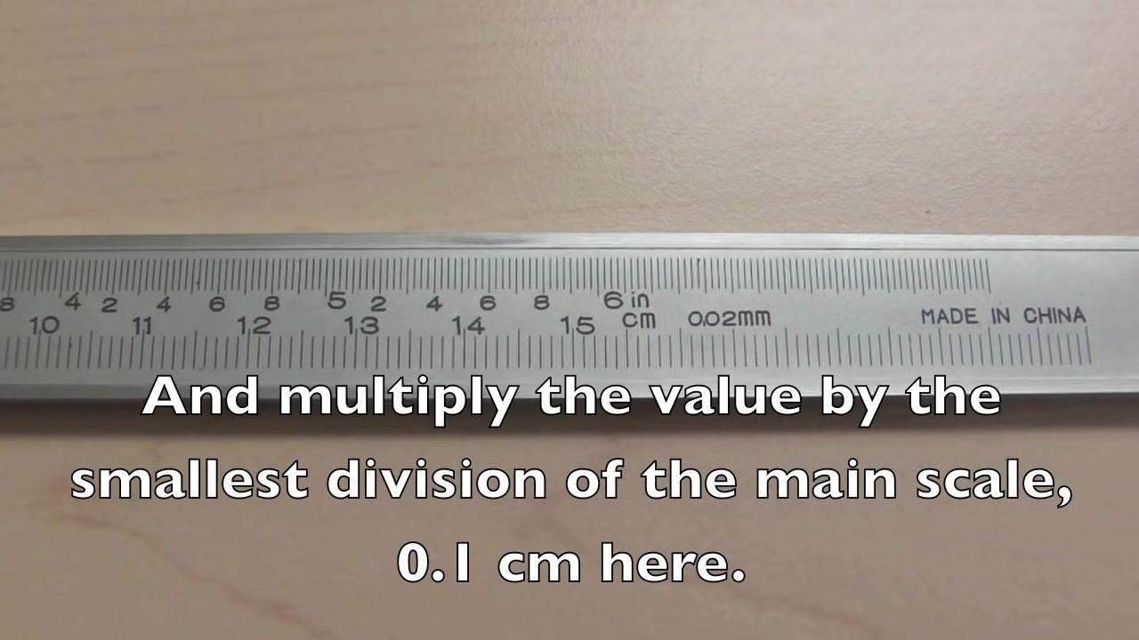 Main scale of the caliper with on-screen text: "And multiply the value by the smallest division of the main scale, 0.1 cm here."