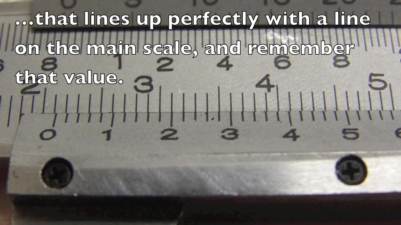 Close-up of the caliper scales with on-screen text: "Now add this value to the measurement from the main scale, 2.1 cm."