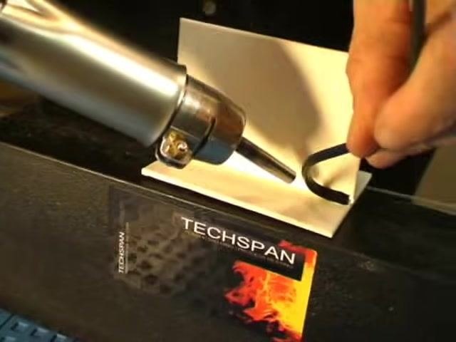 A completed weld showing the welding rod fused along the joint, with the TECHSPAN welding tool set aside